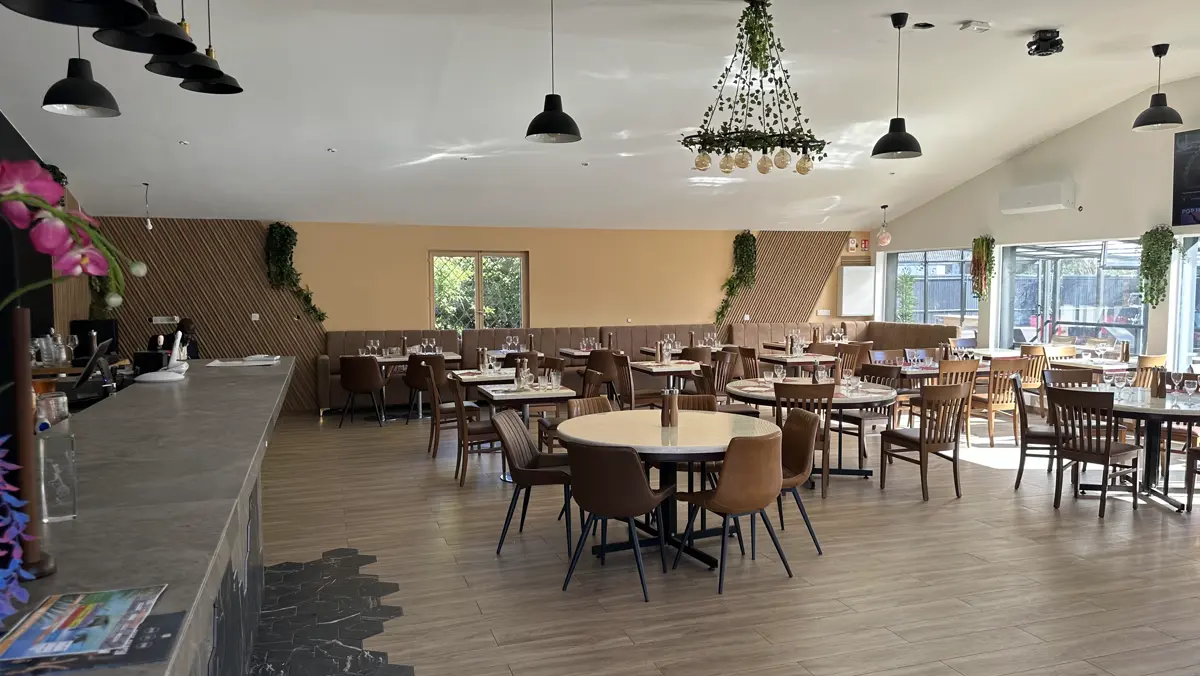 La grande salle et ses tables rondes, prêtes pour un groupe